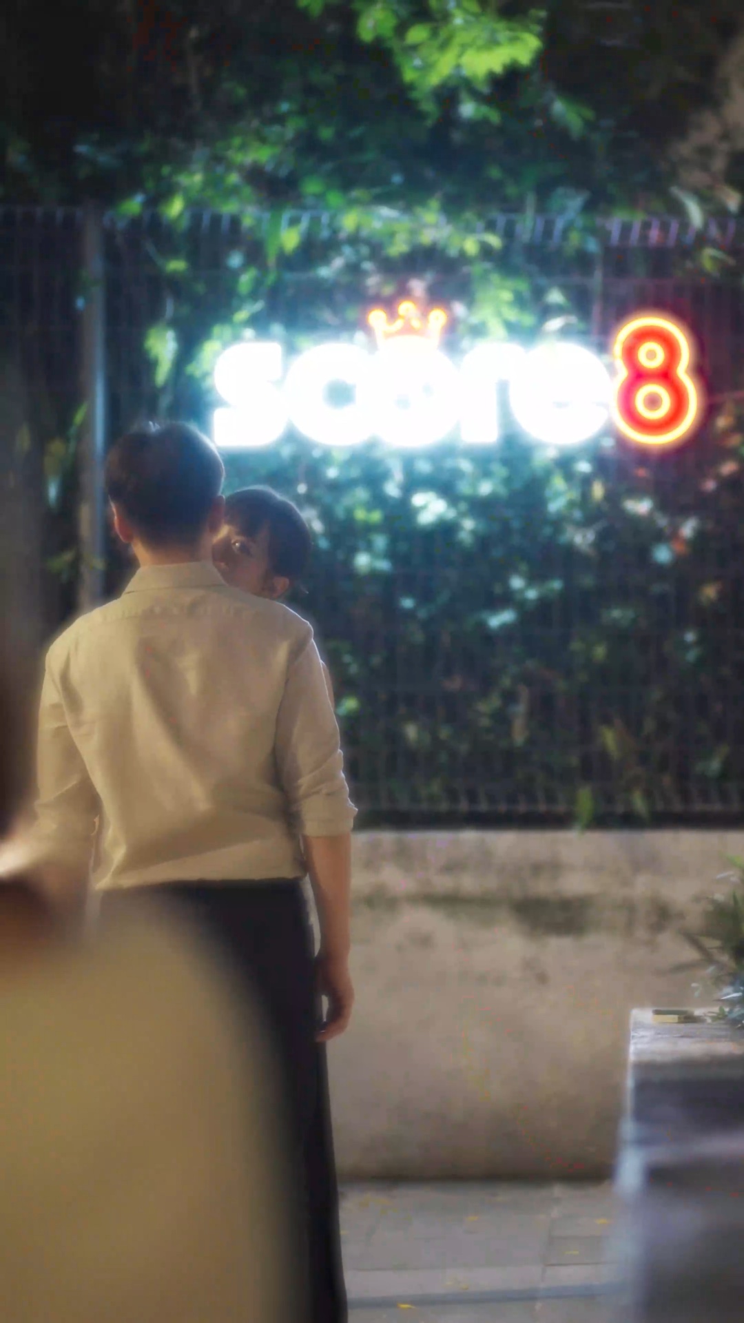 Score8 illuminated logo appearing naturally within a scene from Live Again